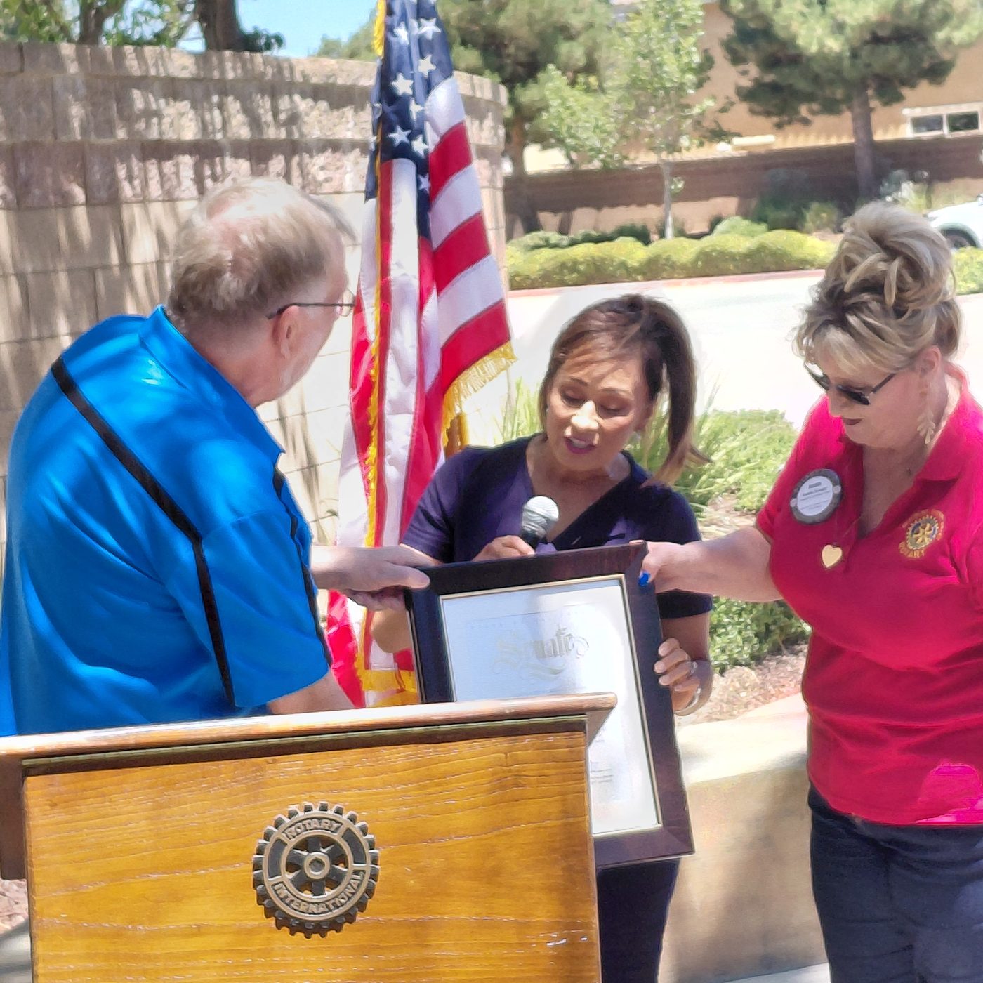 Club President Doug Emery and Director Robin Knight accept a California State certificate from State Senator Rosilicie Ochoa Bogh at the Rotary podium