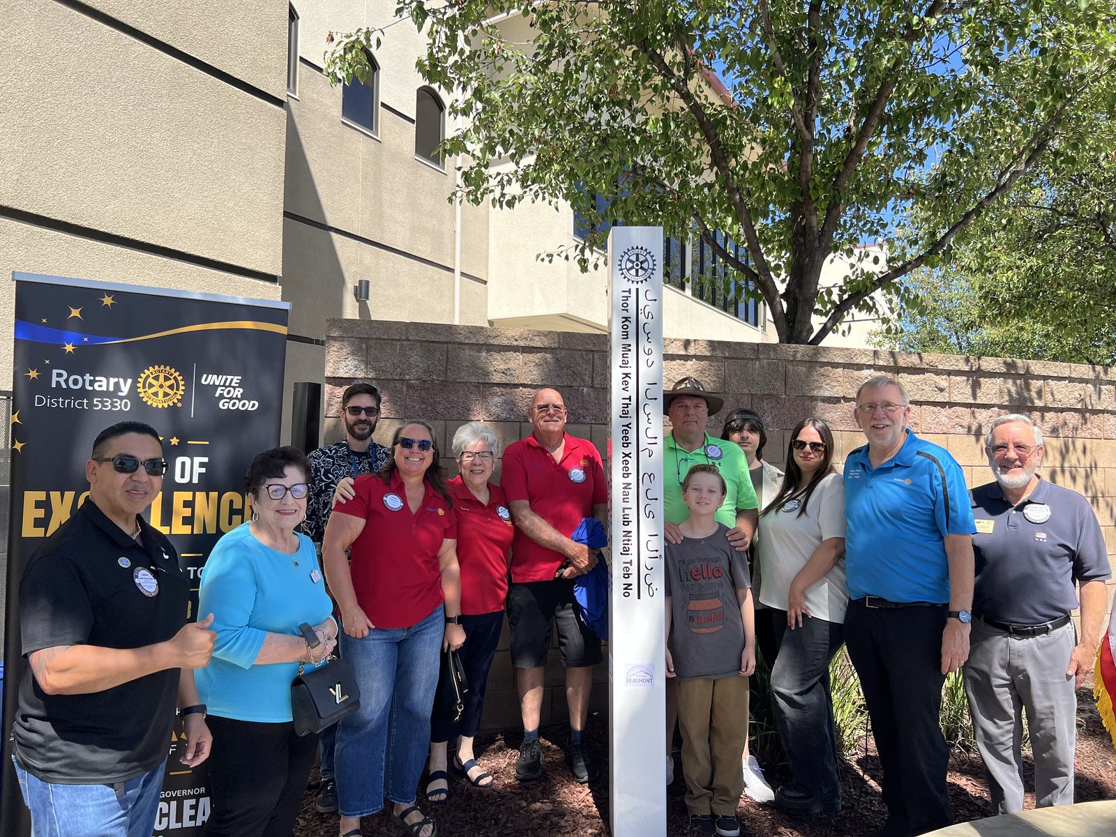 Club members and families gathered around the new Peace Pole at the Chatigny Center