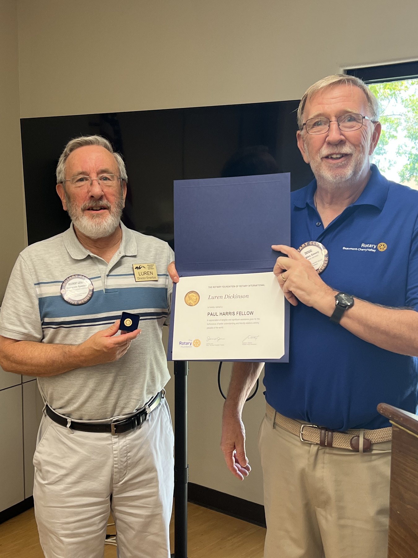 Luren Dickinson and President Doug Emery display Luren's Paul Harris Fellow certificate